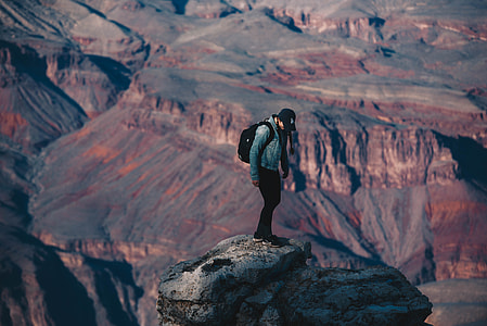man standing on cliff during daytime thumbnail