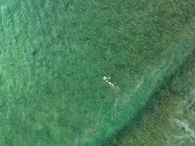 top view photography of boat on green body of water thumbnail