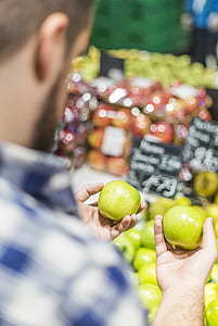 person holding two green apples thumbnail
