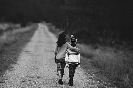 grayscale photography of two children walking on pathway thumbnail