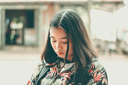 woman wearing red, green, and black floral top and black backpack thumbnail