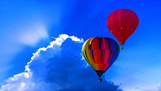person taking photo of two hot air balloons thumbnail