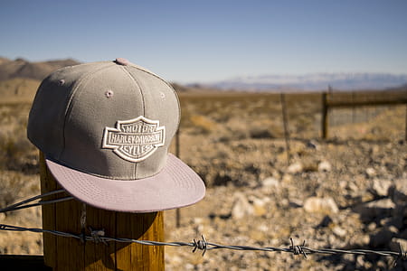 Gray Harley-davidson Motorcycles Flat-brimmed Cap Hanged on Brown Wooden Fence With Gray Barb Wires thumbnail
