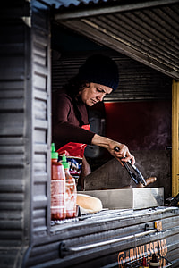 woman cooking sausage inside the food truck thumbnail