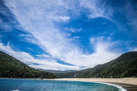 blue sea and green mountains under blue sky thumbnail