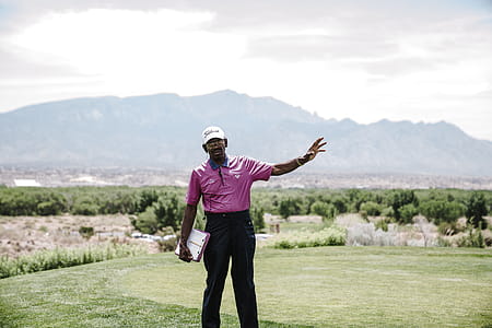 Man Standing on Grass While Raising His Left Arm thumbnail