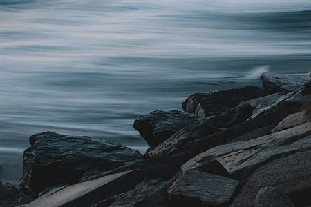 black rock formations near grey body of water thumbnail