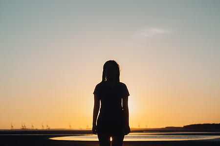 silhouette photo of person standing near body of water thumbnail