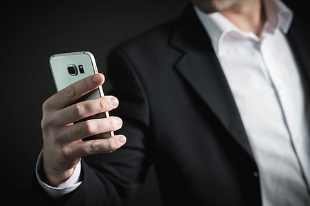 person holding gold Samsung Android smartphone thumbnail