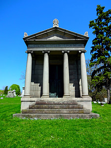 white concrete building with pillars under blue sky at daytime thumbnail