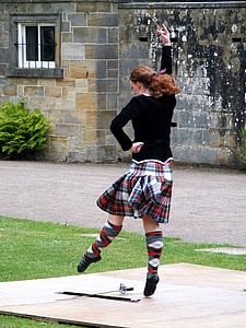 woman dancing on brown wooden panel beside black sword and scabbard during daytime photo thumbnail