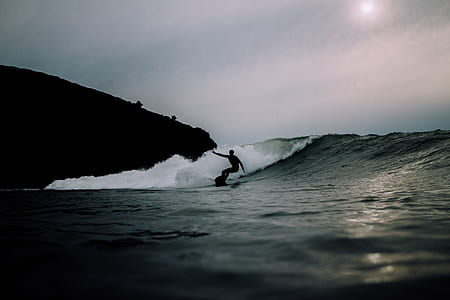 silhouette of man surfing in water thumbnail