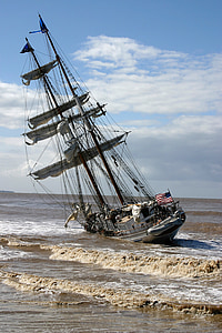 white and brown sail boat on sea shore thumbnail