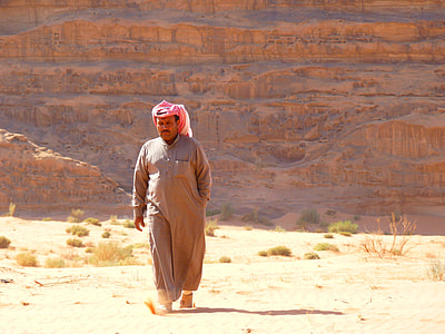 man wearing brown thobe walking on desert thumbnail