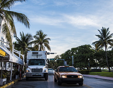 red Ford Crown Victoria beside white truck during daytime thumbnail