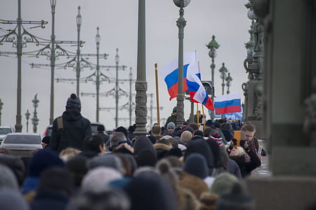 group of people walking beside gray concrete posts thumbnail