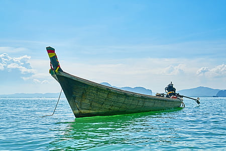 gray wooden outboard boat on body of water thumbnail