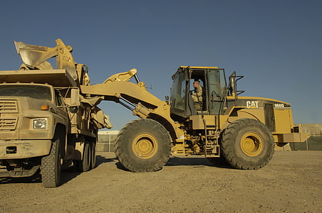 yellow Caterpillar excavator beside dump truck thumbnail