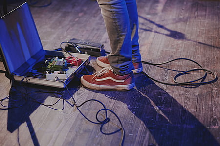 man standing near guitar effects pedal thumbnail