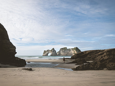 silhouette of person near rock formation beside seashore thumbnail