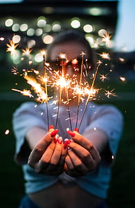 selective focus photography of woman holding sparklers thumbnail