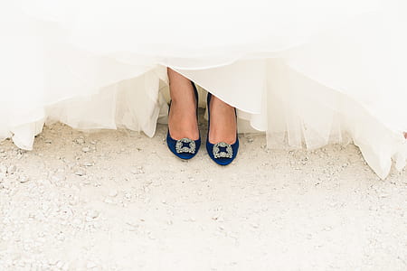 woman in white dress showing her black heeled shoes thumbnail