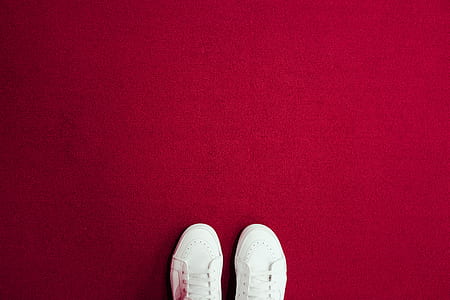 pair of white shoes on red textile thumbnail