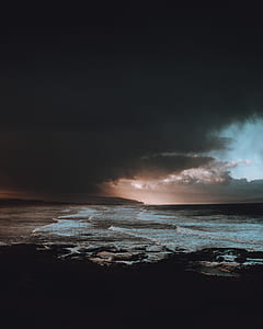 stormy seas covered with black skies during golden hour thumbnail