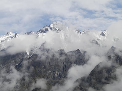 snow capped mountains covered with fogs thumbnail