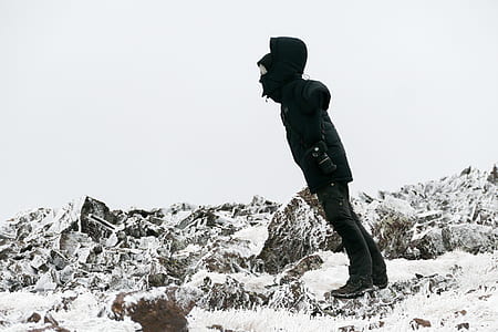 person wearing black jacket standing on snow covered surface thumbnail