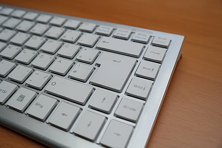 grey keyboard on brown wooden surface thumbnail