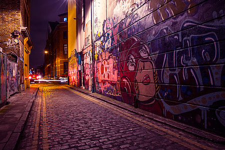 City side street with street art and graffiti captured by night thumbnail