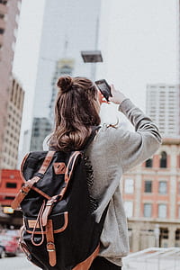 woman in gray sweatshirt using black smartphone thumbnail