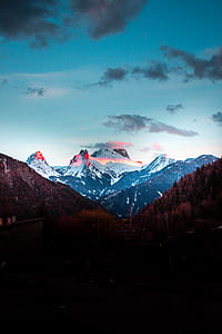 snow-covered mountains under blue and cloudy sky thumbnail