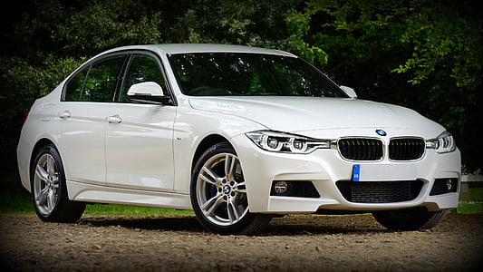 white BMW sedan near trees thumbnail
