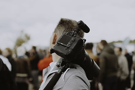 black DSLR camera on man's shoulder thumbnail