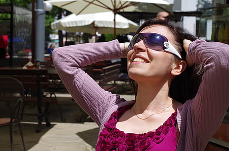 selective focus photography of smiling woman holding her hair during daytime thumbnail