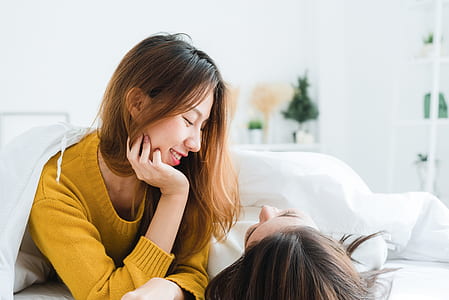 Woman Wearing Sweatshirt Lying on White Mattress thumbnail