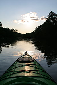 green kayak on water near trees thumbnail