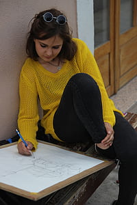 woman drawing while sitting on corner thumbnail