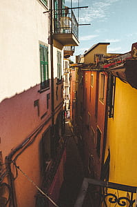 pathway between red concrete buildings thumbnail
