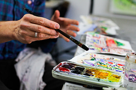 man wearing blue and purple sport shirt painting a picture selective-focus photography thumbnail