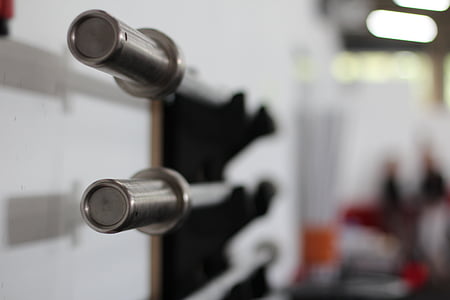 two gray metal barbell bars near wall thumbnail