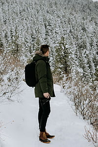 photo of man standing and holding DSLR camera thumbnail