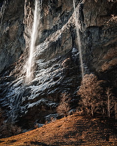 waterfalls pouring down to rock near trees thumbnail