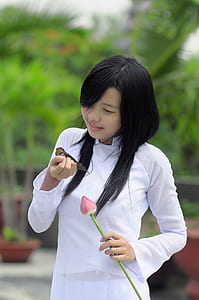 woman in white long-sleeved dress holding brown bird thumbnail