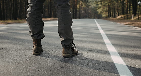 person in gray pants standing on gray road thumbnail