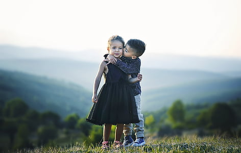 selective focus photography of boy kissing girl's cheek thumbnail