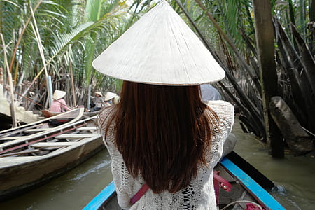 woman wearing while conical riding on boat thumbnail