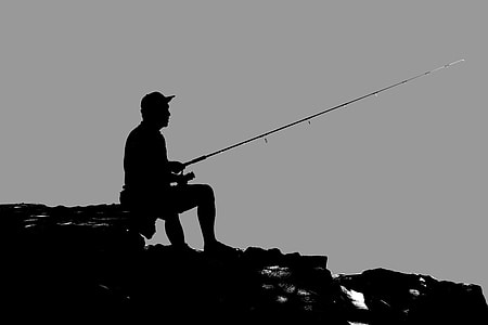 silhouette of man fishing on seashore thumbnail